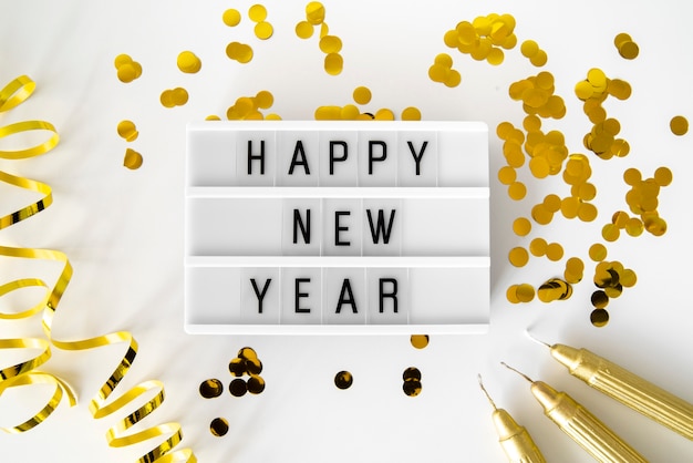 Free photo golden sequins and ribbons with happy new year quote