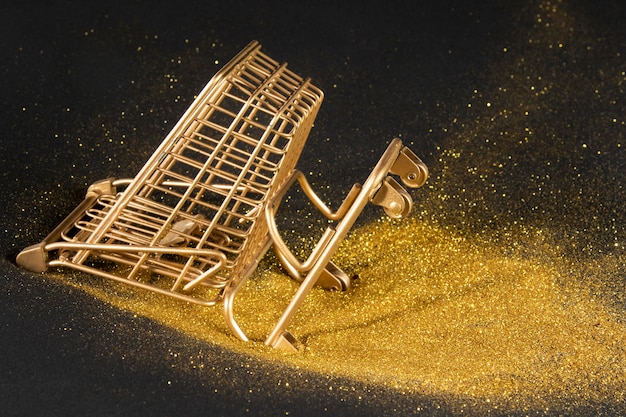 Free photo golden shopping cart on black background