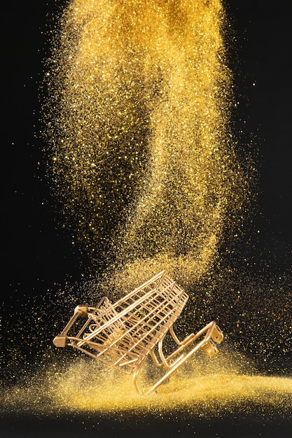 Free Photo golden shopping cart in golden glitter