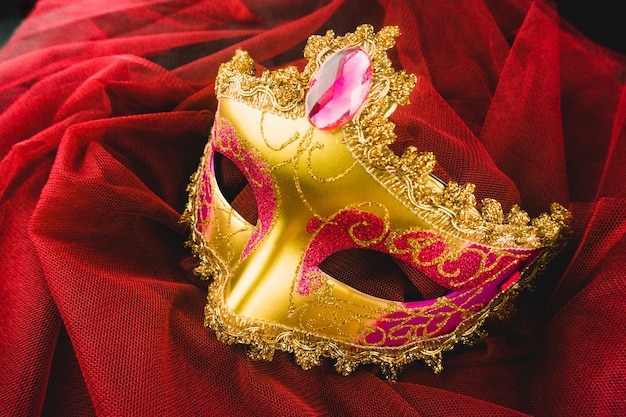 Golden venetian mask on a red fabric