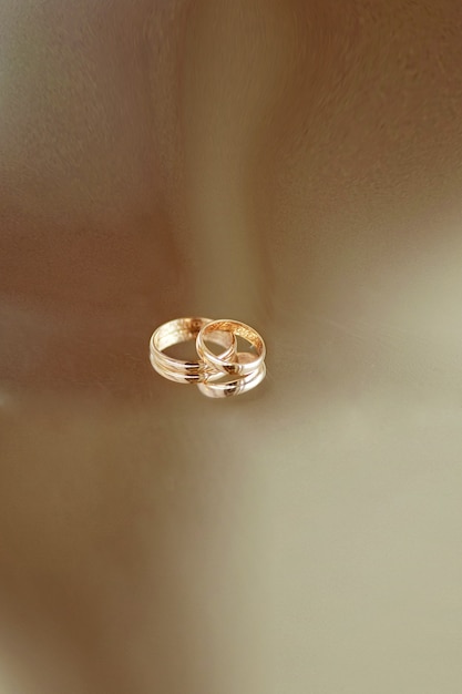 Free photo golden wedding rings lie on transparent table