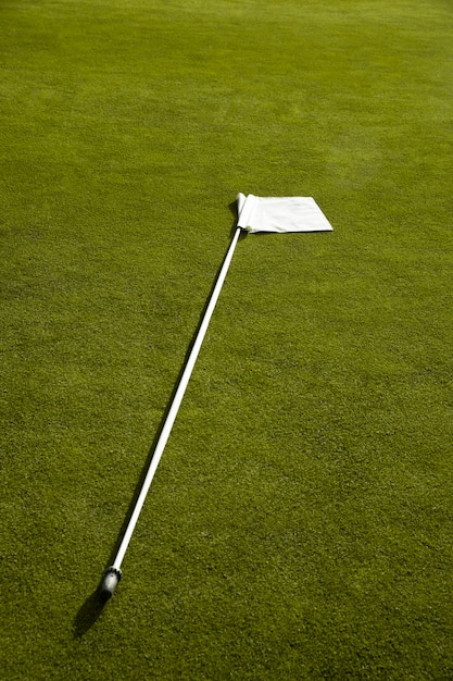 Golf flag waving on golf course ground