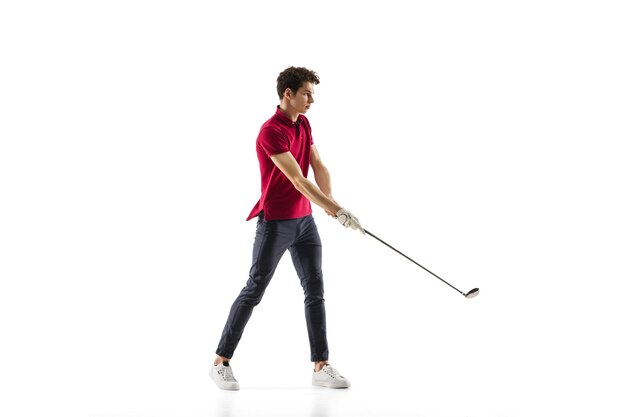 Golf player in a red shirt taking a swing isolated on white studio background