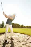 Free photo golfer about to hit ball out of a sand bunker