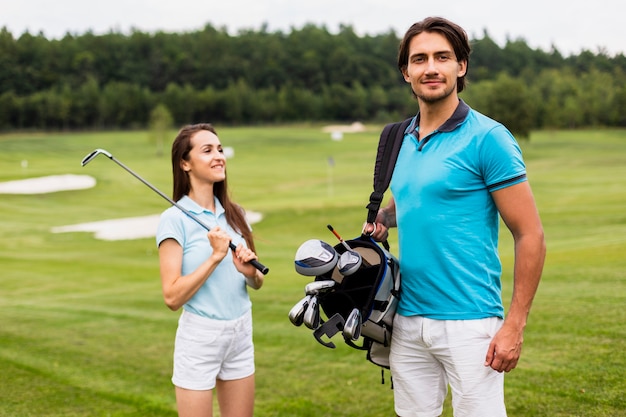 Free photo golfing parteners carrying golf bag