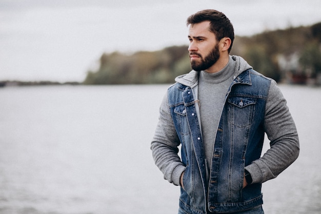 Good looking bearded man by the river in park