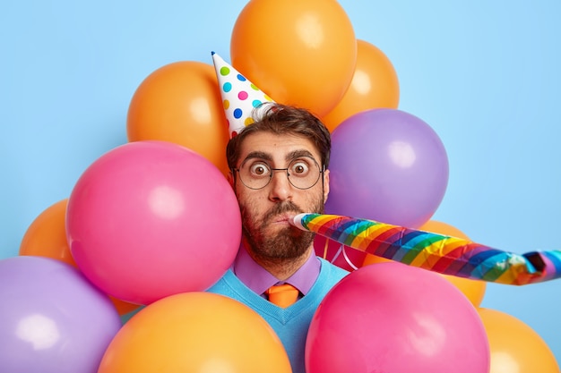 Good looking guy surrounded by party balloons posing