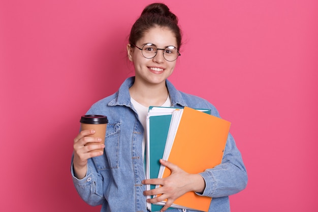 Free photo good looking student girl posing isolated over rosy background, lady wearing denim jacket and eyewear