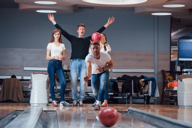 Free photo good luck. young cheerful friends have fun in bowling club at their weekends