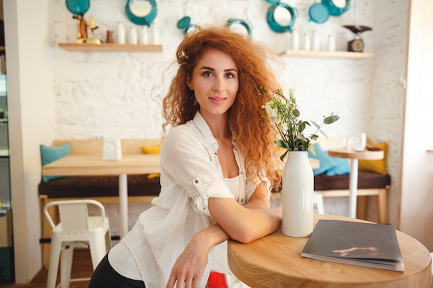 Gorgeous beautiful redhead young lady posing in cafe