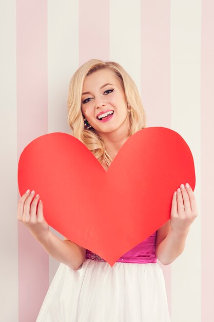 Gorgeous blonde woman with big red heart 
