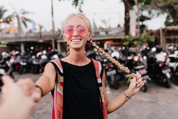 Free photo gorgeous european female model with braids spending summer day outdoor.