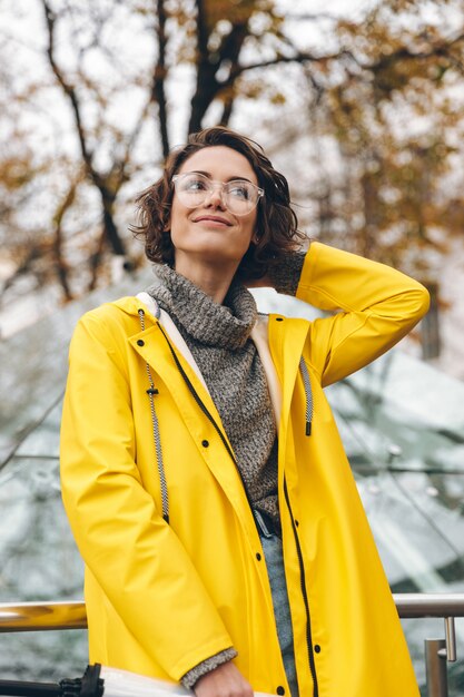 Gorgeous woman with beautiful curly hair walking through city center on weekend taking pleasure while spending time alone