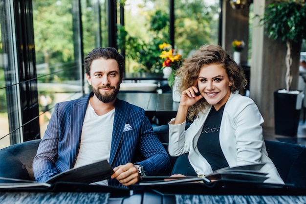 Gorgeous young and pretty couple with menu in a restaurant making order