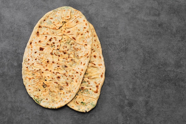 Free Photo gozleme a traditional vegetarian dish of turkish or caucasian cuisine in the form of a flatbread stuffed with greens and cheese wrapped inside baked in pan top view with copy space