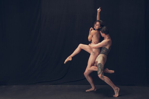 Graceful classic ballet dancers isolated on black studio.