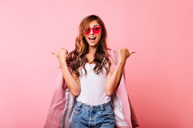 Graceful ginger young woman in trendy glasses chilling during portraitshoot. portrait of enthusiastic cute girl expressing good emotions.