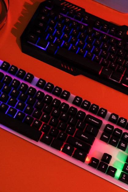 Free photo gradient illuminated neon gaming desk setup with keyboard