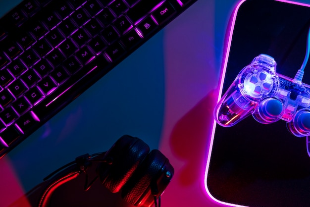 Free photo gradient illuminated neon gaming desk setup with keyboard