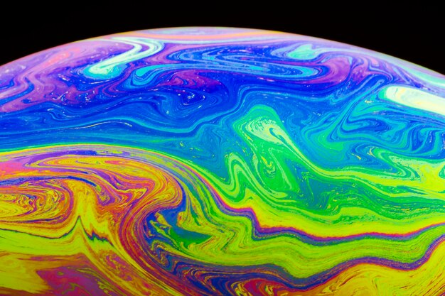 Gradient multicolored soap bubble on black background