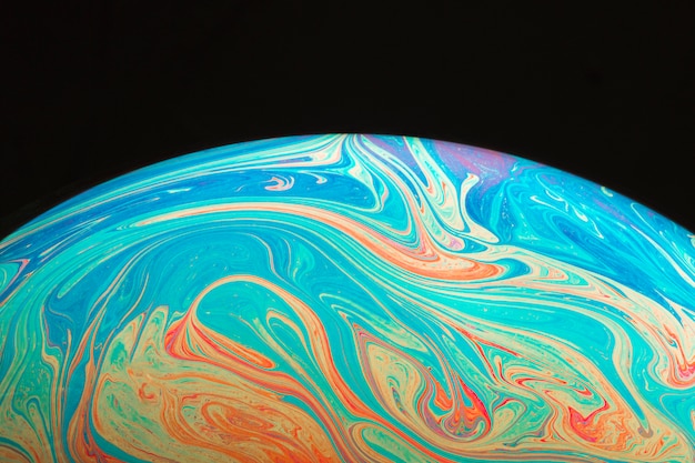 Free photo gradient rippled colorful abstract soap bubble on black background