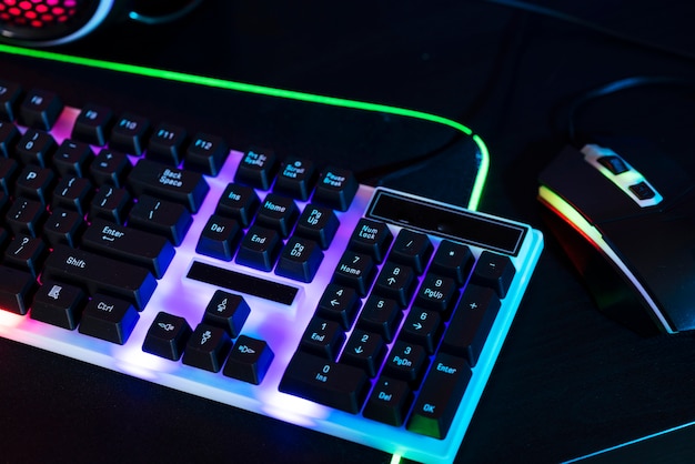 Free photo gradient view of illuminated neon gaming desk setup with keyboard