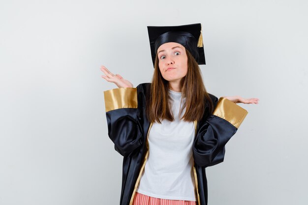 Graduate woman showing helpless gesture in casual clothes, uniform and looking confused , front view.