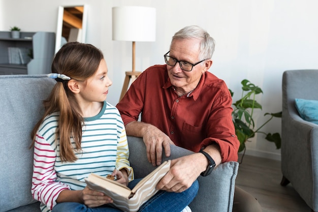 Grandfather and girl holding book