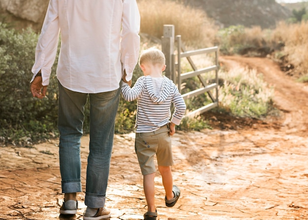 Free photo grandfather and grandson walking at the farm