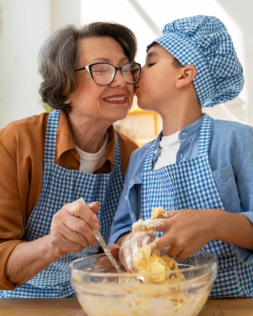 Free photo grandma cooking in the kitchen with grandchild