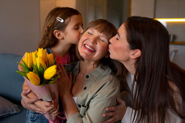 Grandmother being kissed on the cheek by family