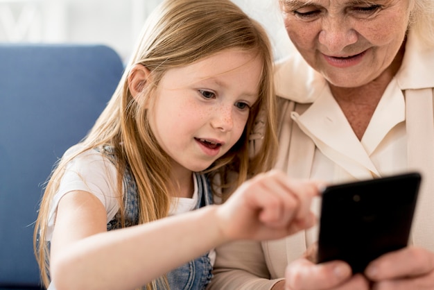 Grandmother and girl looking at mobile