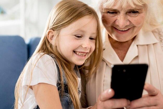 Free photo grandmother and girl looking on mobile