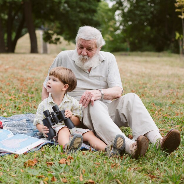 Grandpa and grandson in parc with binocular