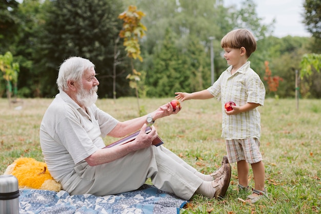 Free photo grandpa and grandson at picnic in nature