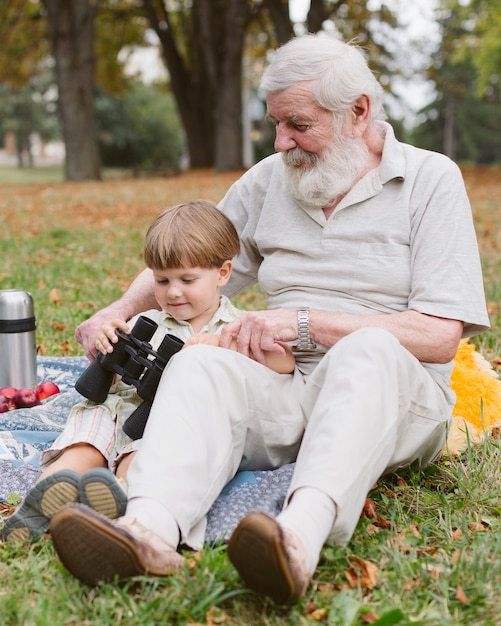 Free photo grandpa showing binocular to grandson