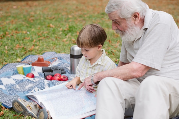 Grandpa showing picture on book to grandson