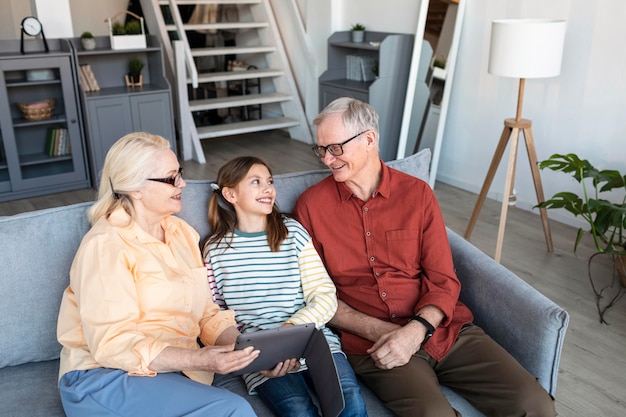 Grandparents and girl with laptop medium shot