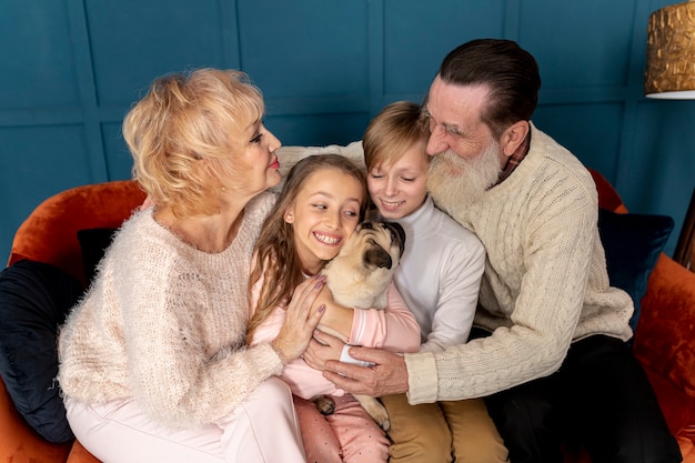 Grandparents and grandchildren playing with dog together