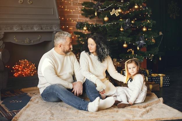 Grandparents sitting with their granddaughter. Celebrating Christmas in a cozy house.