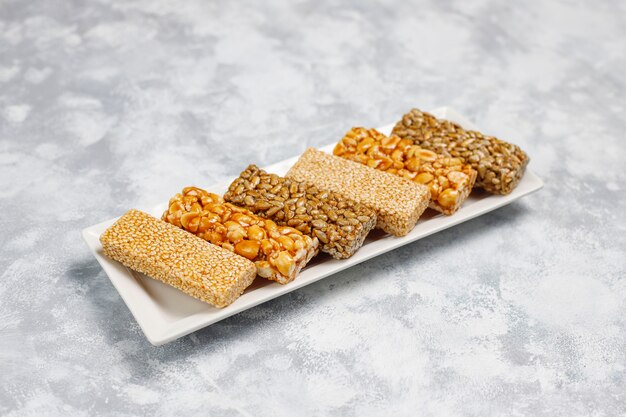 Granola bar. Healthy sweet dessert snack. Sesame, peanut, sunflower in honey. Gozinaki is Georgian national food, oriental sweet. Top view on concrete 