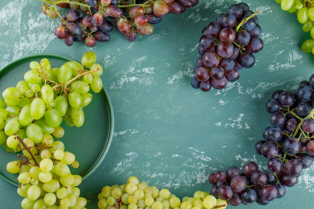 Grape clusters in a tray flat lay on a plaster background