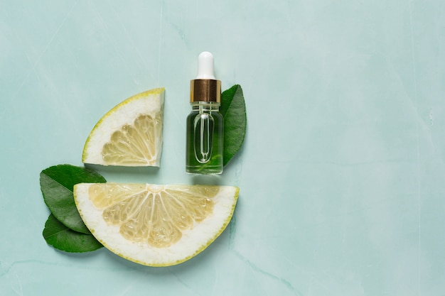 Grapefruit oil serum bottle put on green light background