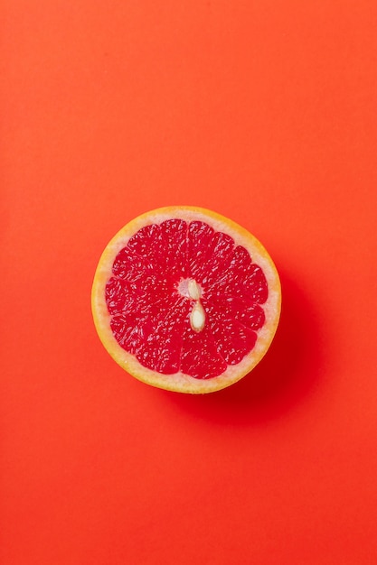 Free photo grapefruit slice isolated on red surface