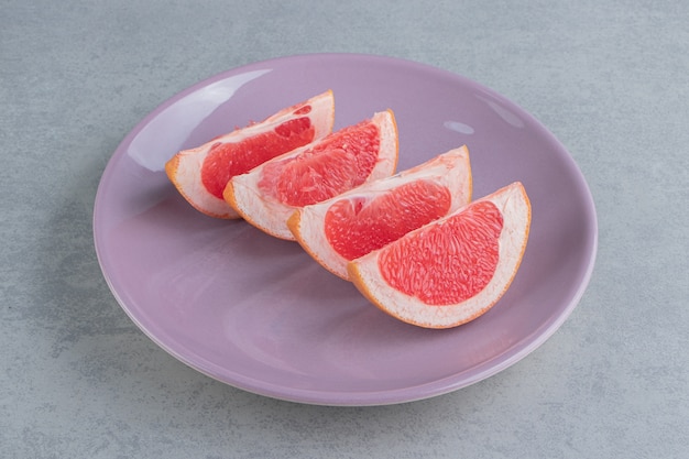 Grapefruit slices on a platter on marble 