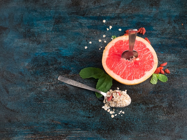 Free photo grapefruit with oatmeal in spoon on table