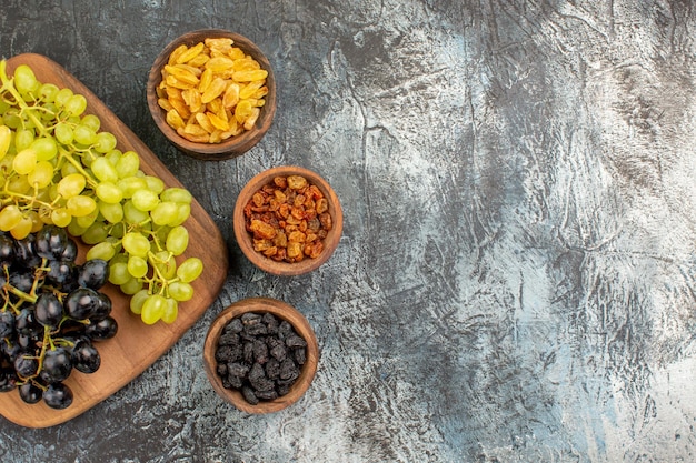 Free photo grapes the appetizing dried fruits tasty green and black grapes on the board