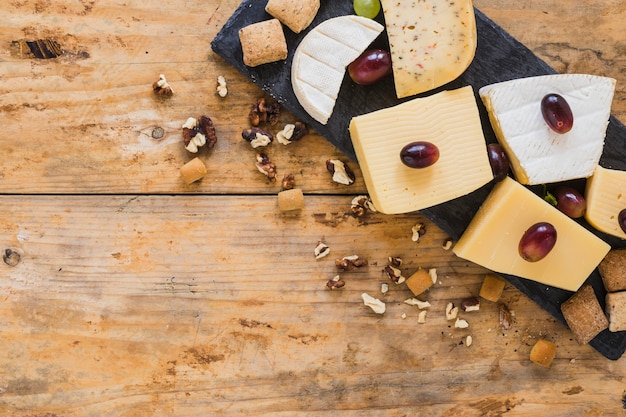 Free photo grapes on cheese blocks with dried fruits on table