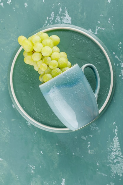 Free photo grapes in a cup top view on plaster and tray background