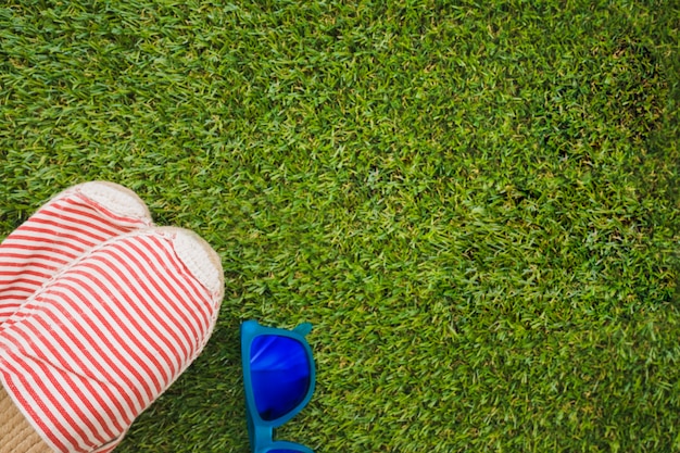 Grass surface with sunglasses and summer shoes